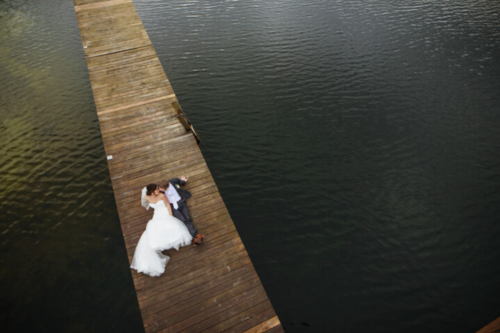 Couple sitting on the dock shot from above.