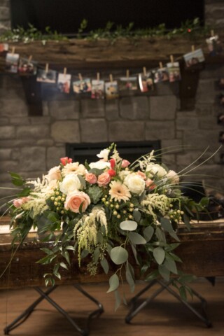 Flowers in front of fireplace.