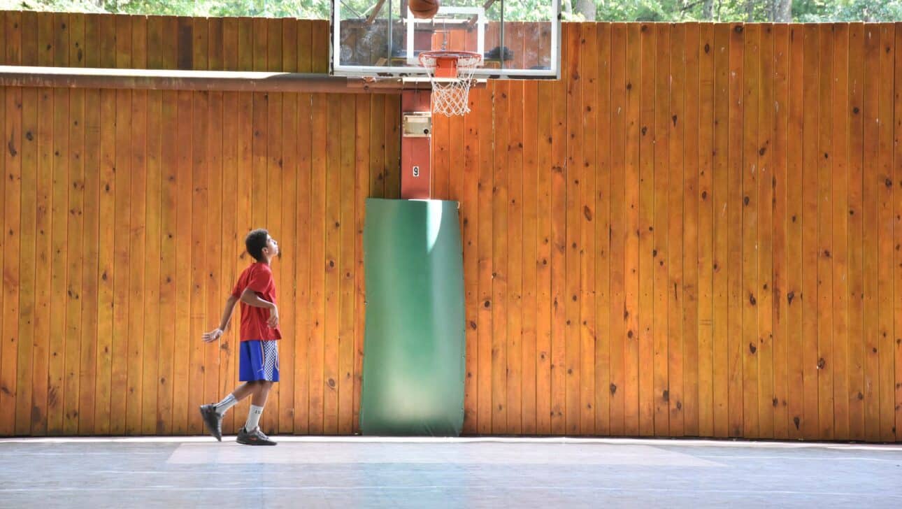 boy shooting basketball.