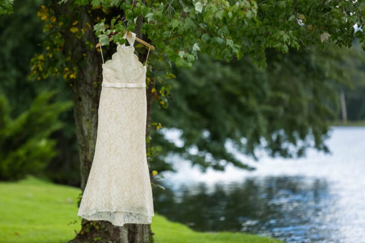 wedding dress hanging by a lake.