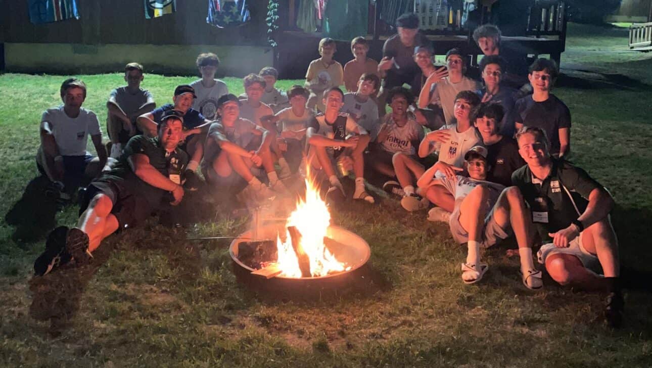 large group in front of a campfire.