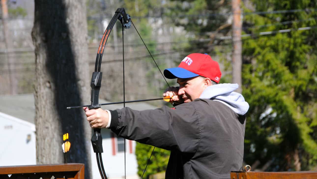 man aiming a bow and arrow.