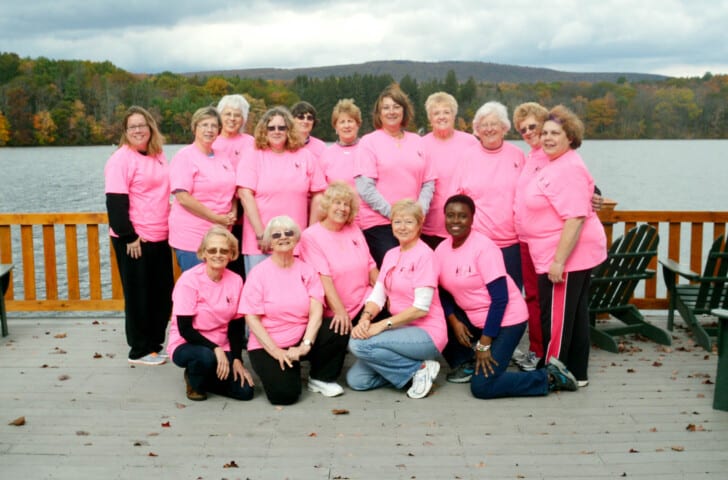 women in pink shirts on a dock.