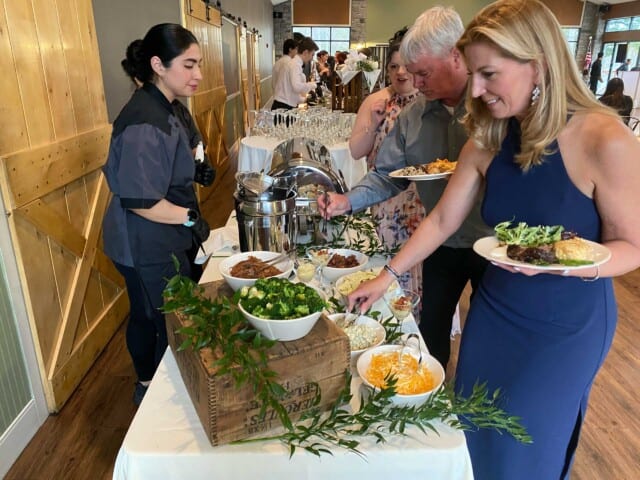 people getting food at a buffet at a special event.