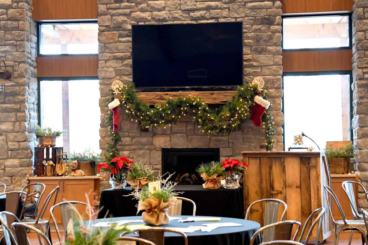 fireplace decorated for christmas in a large party room.