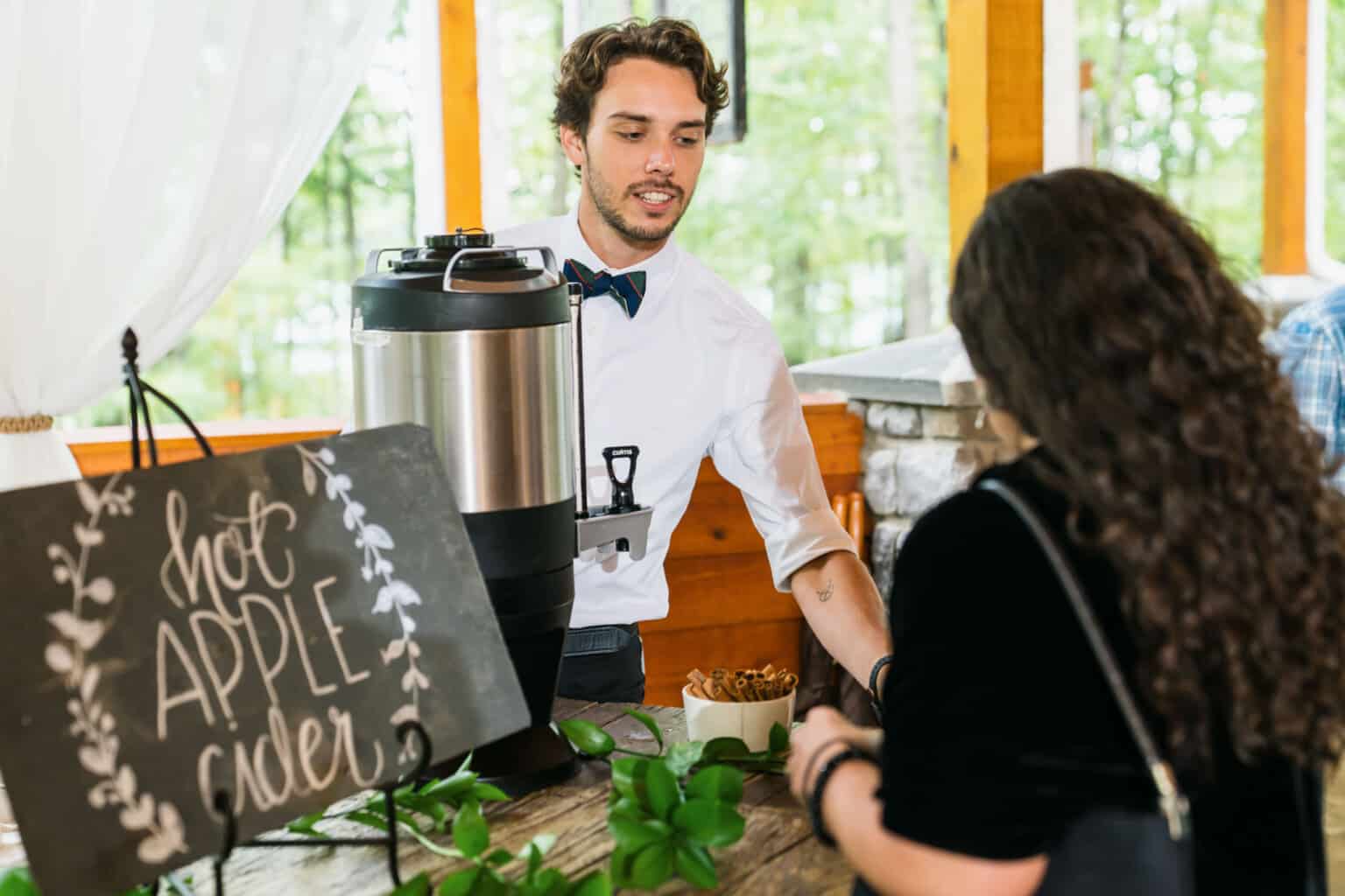 waiter serving at a hot apple cider station.
