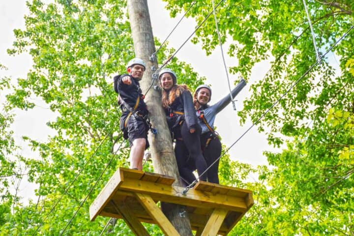 three people on the starting tower for a zipline