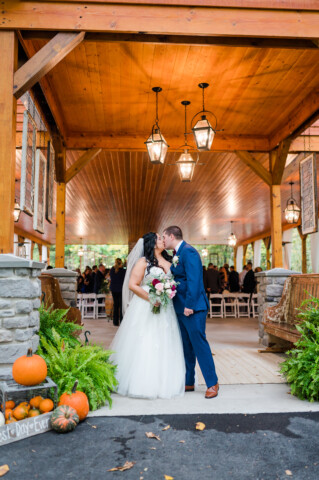 Couple kissing in pavilion entryway.