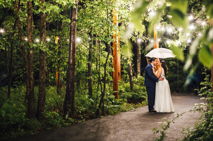 Couple under market light walkway with umbrella.