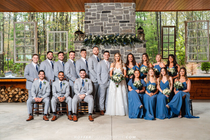 Posed wedding party photo in front of fireplace.