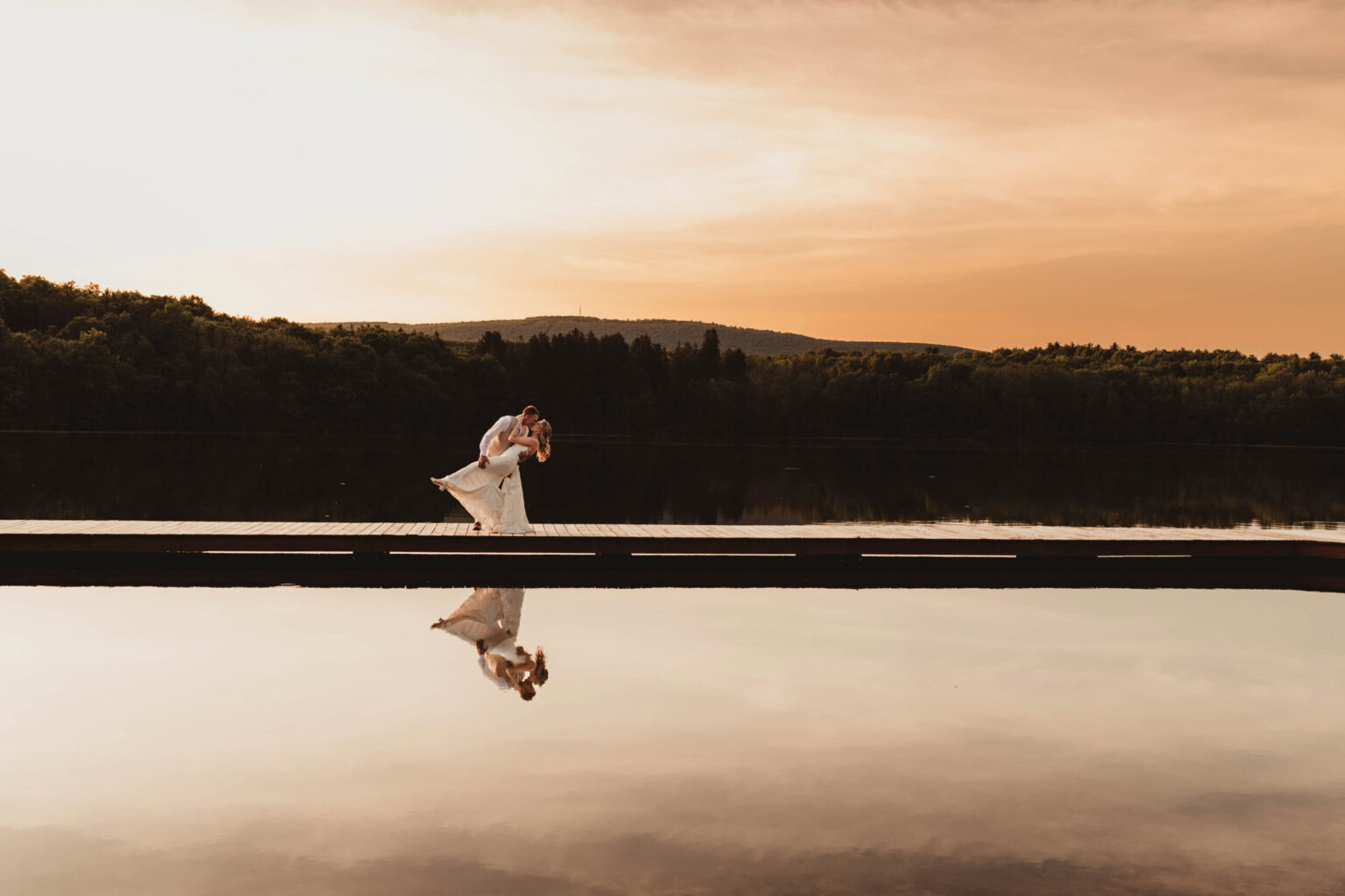 Bride & Groom on dock at sunset.