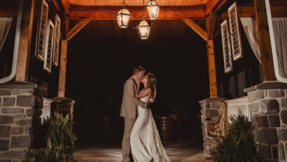 Bride and groom share a kiss in the pavilion entryway.