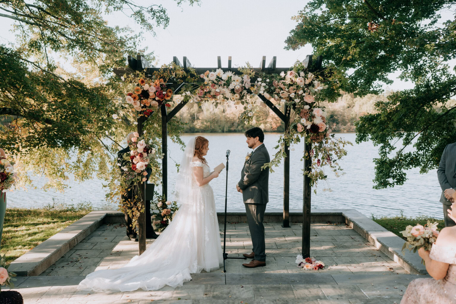 Couple saying their vows at the lakeside terrace ceremony site.