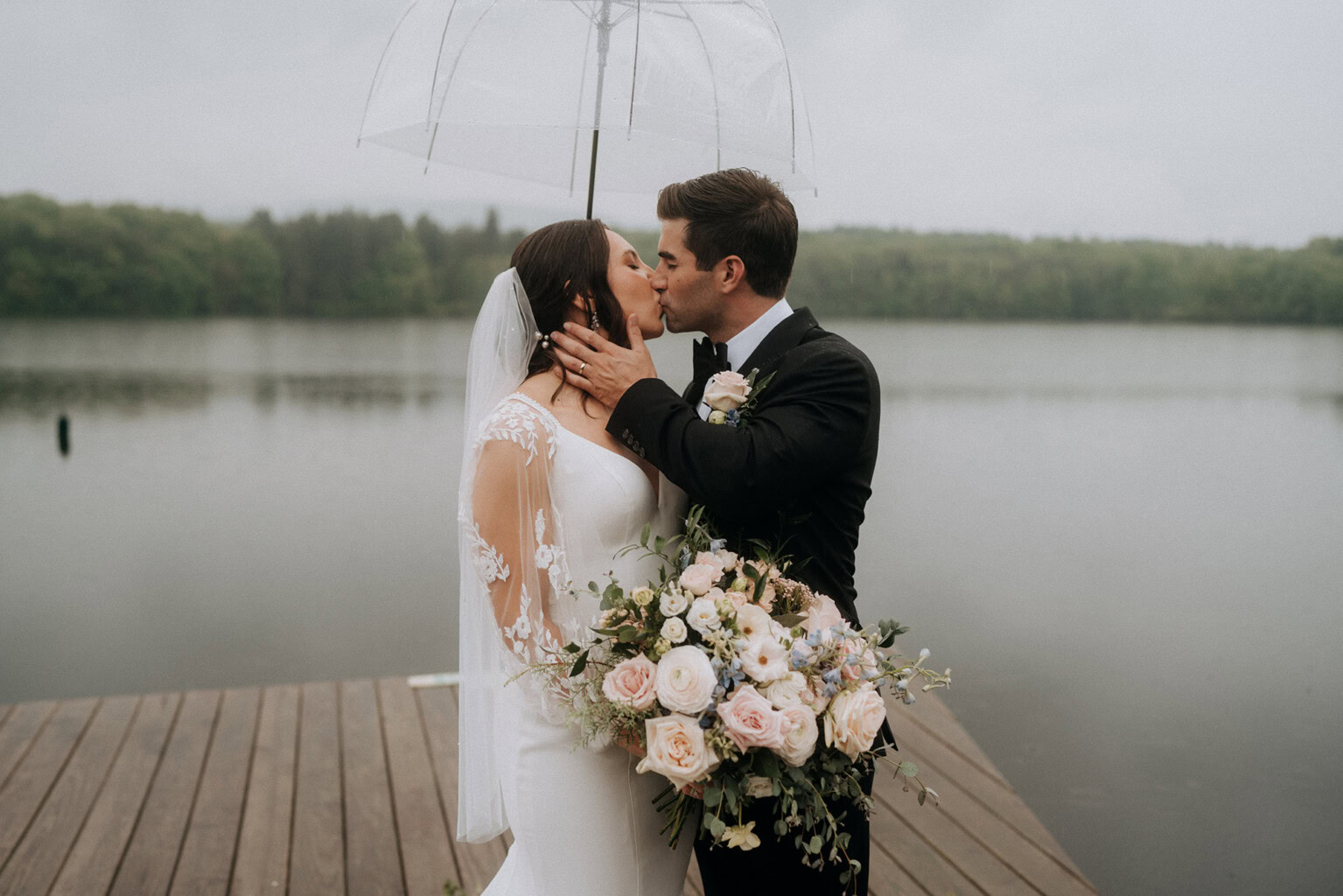 Couple kissing in the rain on the dock with Trout Lake behind