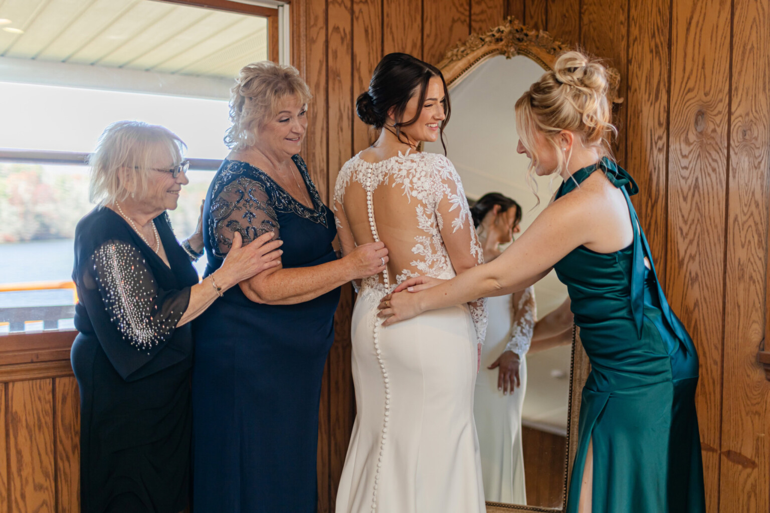 Bride and her family in front of the full length mirror in the wedding suite.