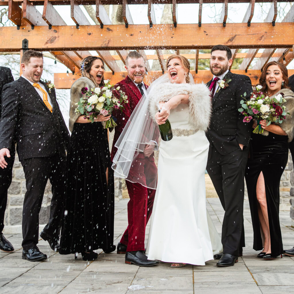 Winter Weddings - Couple celebrating with champagne under Stone Overlook Pergola