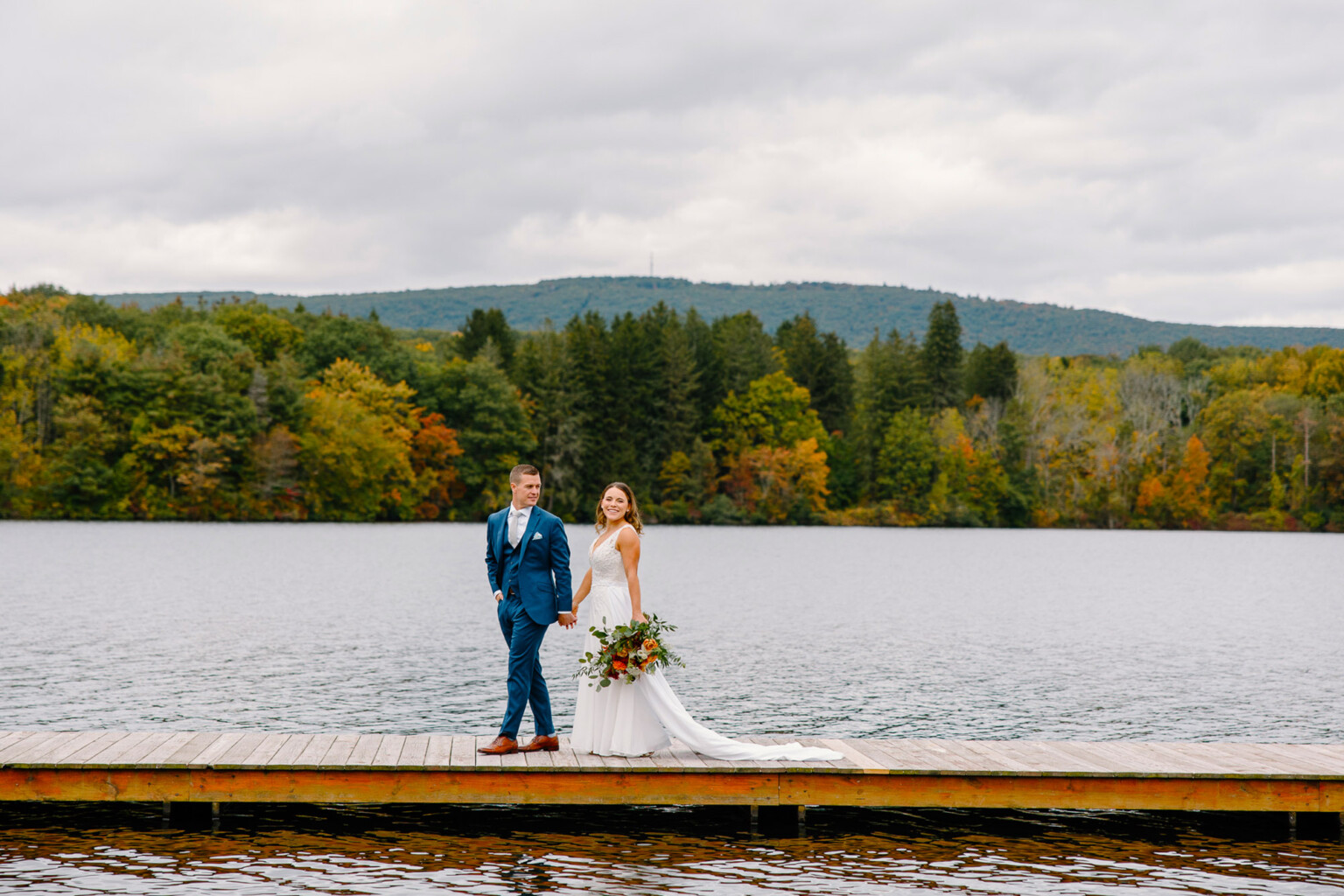 Fall foliage as couple walk on dock