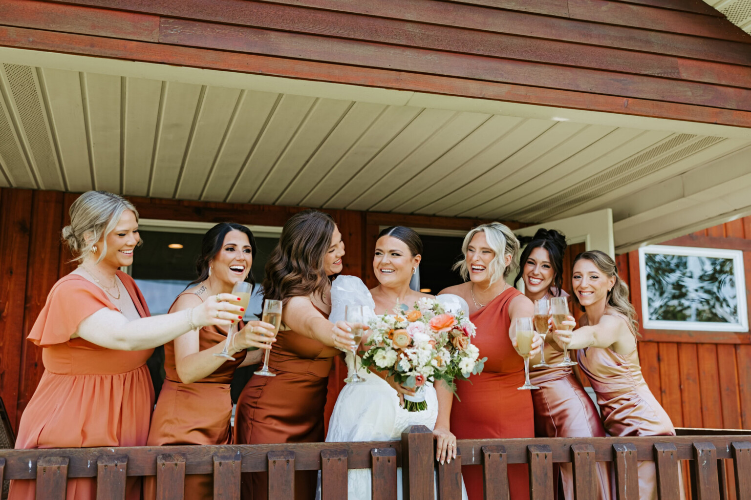 Bridal party toasting on the back deck of the getting ready cabin.