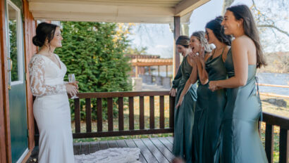Bridesmaids reacting to the brides dress on the back deck of the getting ready cabin.