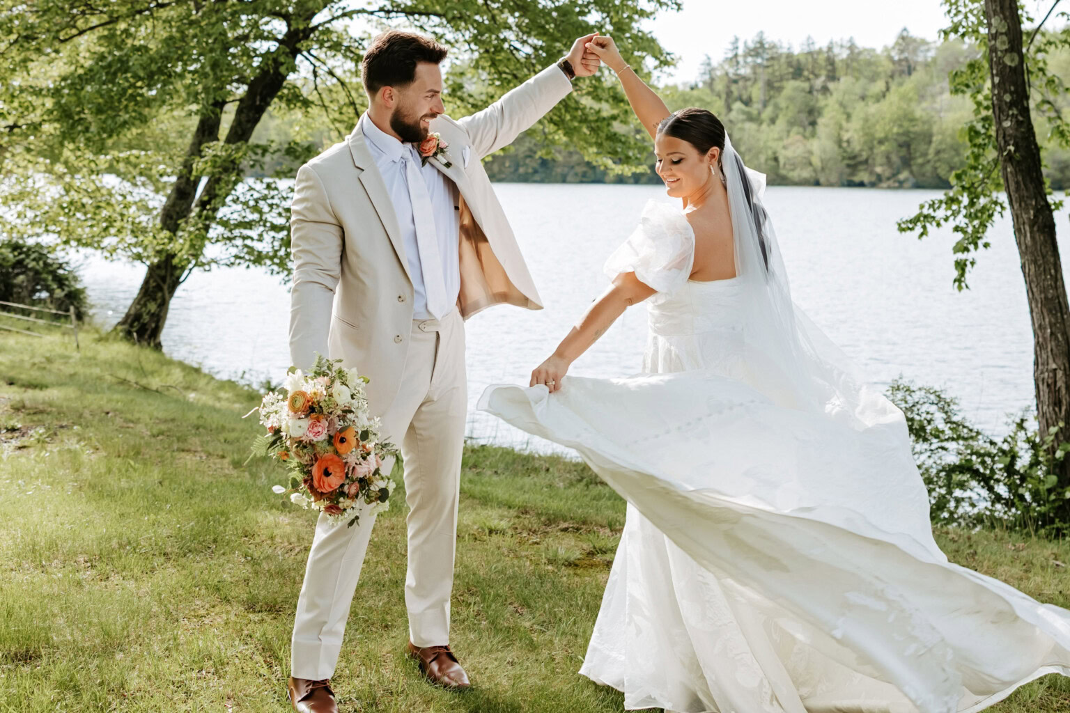 Groom twirls bride lakeside