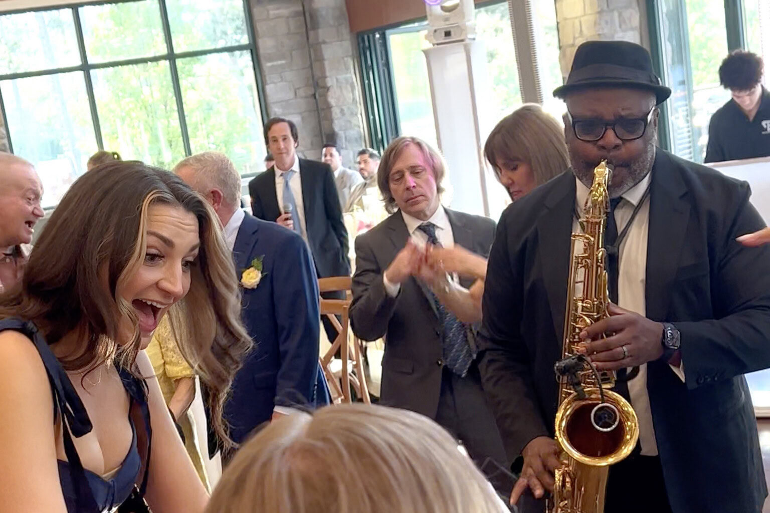 Saxaphone player amongst guests on the dance floor.